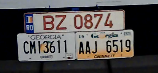 100 percent crop from the rear camera of the same plates with the room lights on, all three cleanly readable